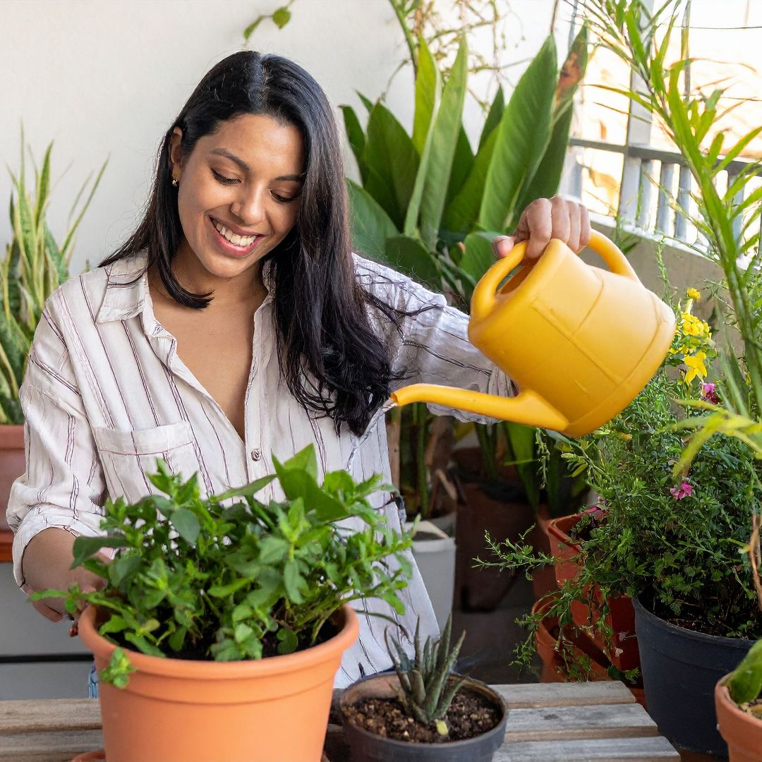 Woman watering plants in a garden setting